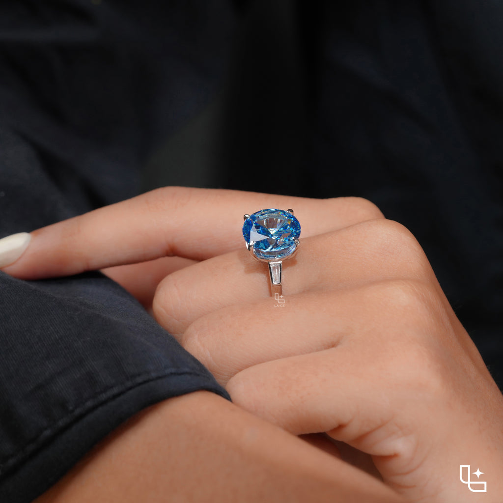 Round Blue Center Stone Solitaire Ring with Baguette Side Accents