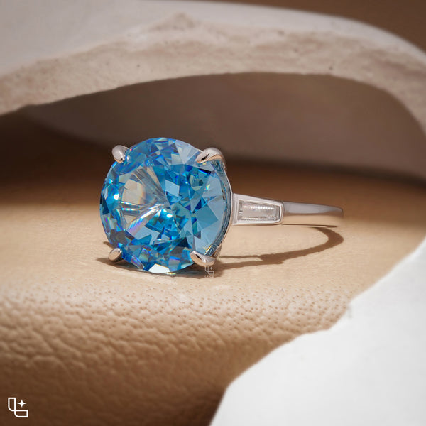 Round Blue Center Stone Solitaire Ring with Baguette Side Accents