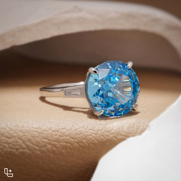 Round Blue Center Stone Solitaire Ring with Baguette Side Accents